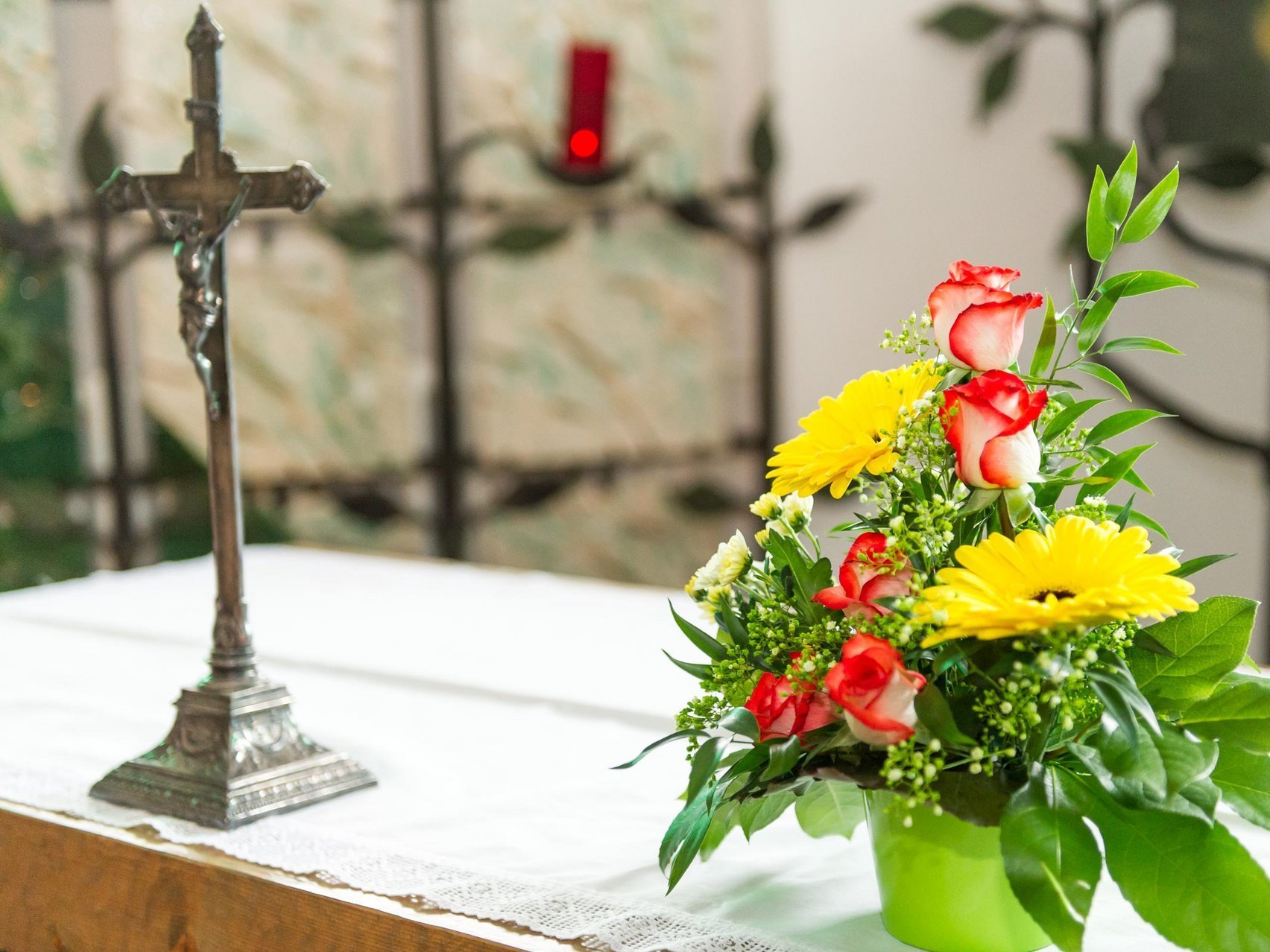 Nahaufnahme: Altar mit Kreuz und Blumen