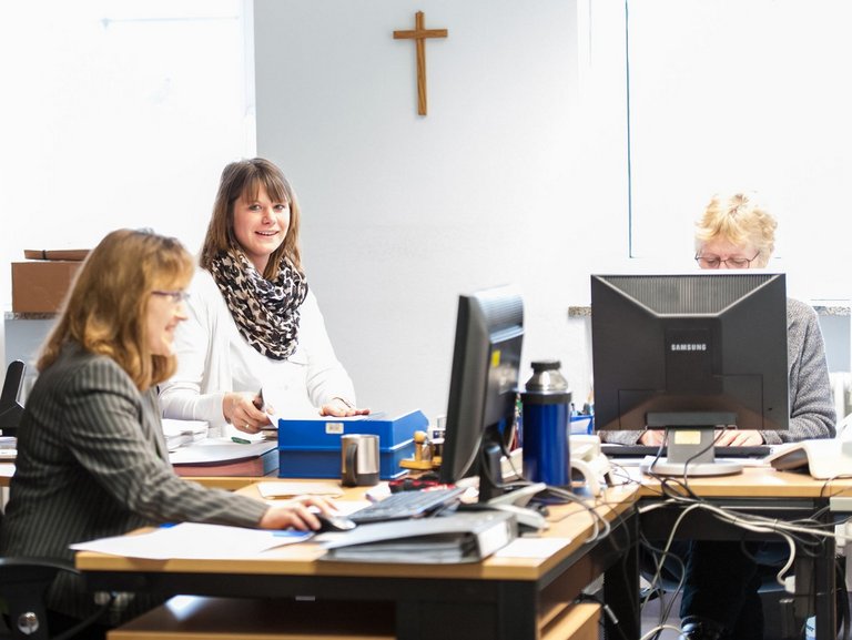 Arbeit im Büro - drei Frauen arbeiten an ihren Computern, oder schlagen im Ordner nach